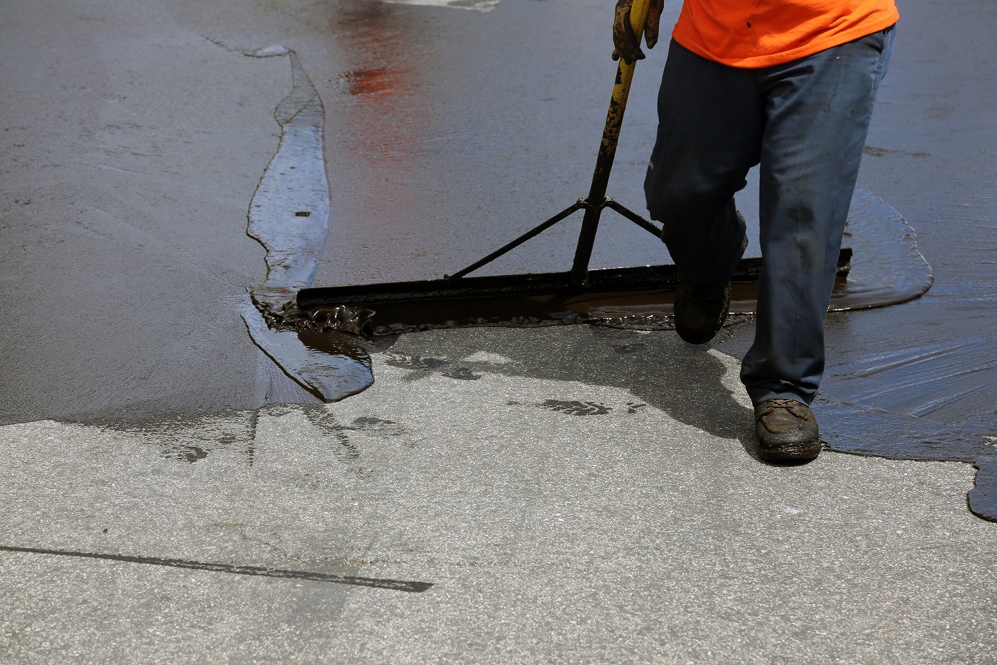 worker sealcoating asphalt
